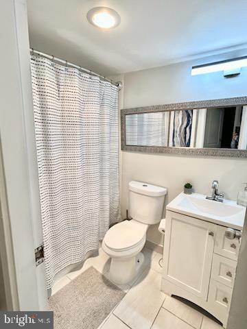 bathroom with tile patterned flooring, vanity, and toilet