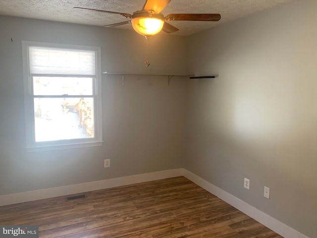 unfurnished room with dark hardwood / wood-style flooring, a textured ceiling, and ceiling fan