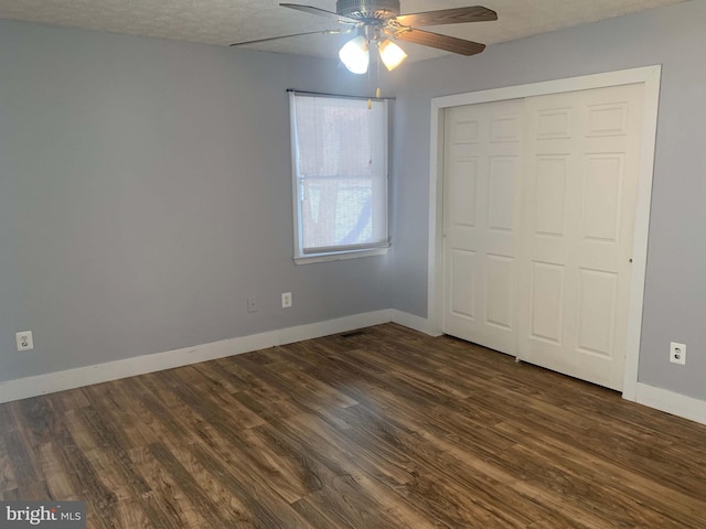 unfurnished bedroom featuring ceiling fan, dark hardwood / wood-style flooring, a closet, and a textured ceiling