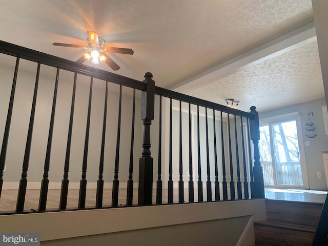 stairs with a textured ceiling and ceiling fan