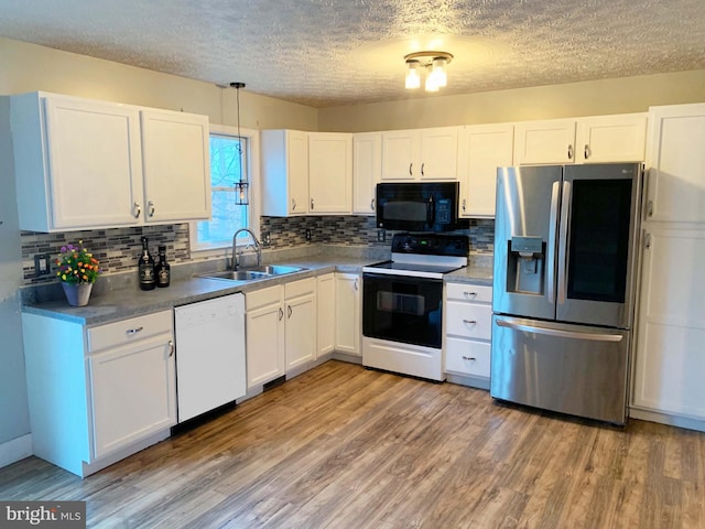 kitchen featuring electric range oven, sink, white cabinets, dishwasher, and stainless steel fridge with ice dispenser