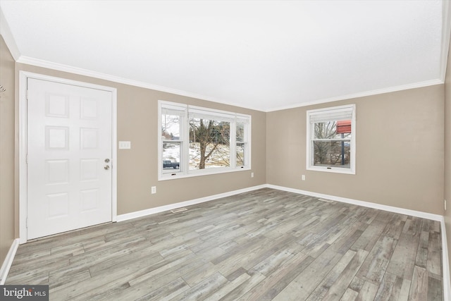 foyer entrance with light wood-type flooring and crown molding