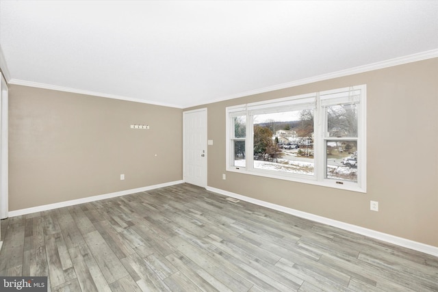 unfurnished room featuring light wood-type flooring and crown molding