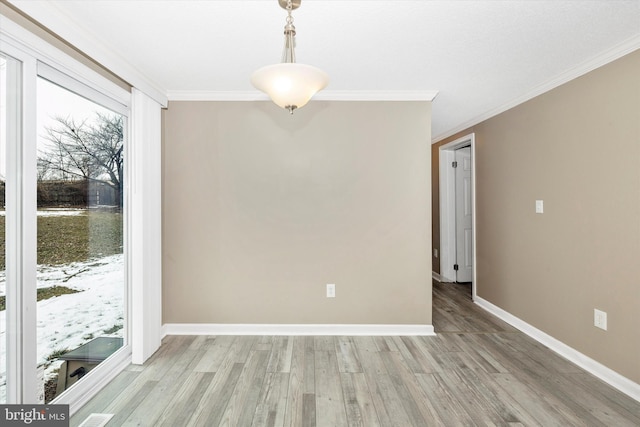 unfurnished dining area with light wood-type flooring and crown molding