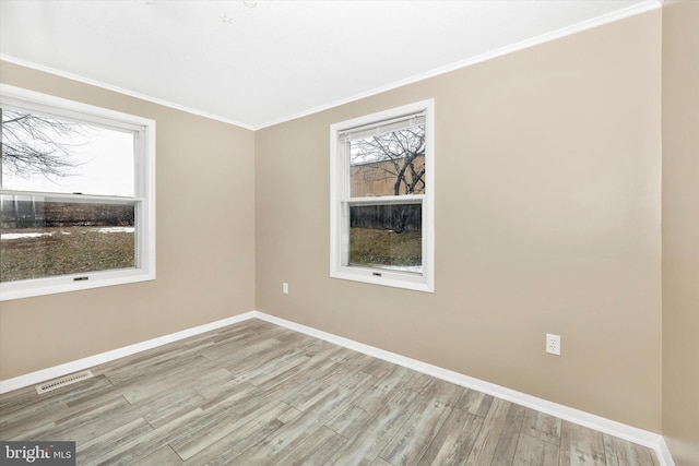 spare room with crown molding and light hardwood / wood-style flooring