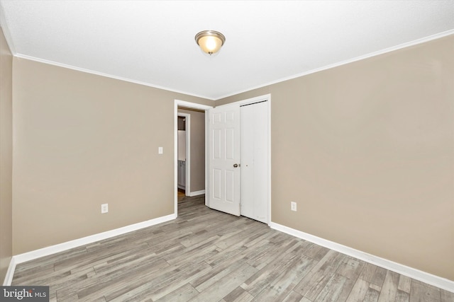 spare room featuring crown molding and light hardwood / wood-style floors