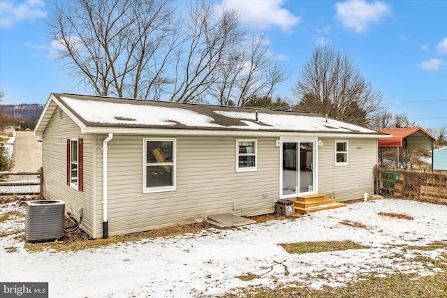 snow covered house featuring central AC