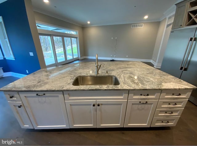 kitchen featuring light stone countertops, white cabinetry, high end fridge, and sink