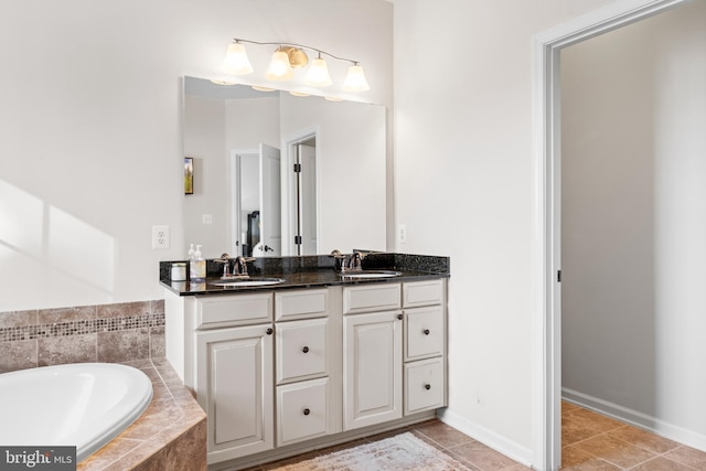 bathroom with vanity, tile patterned flooring, and tiled bath