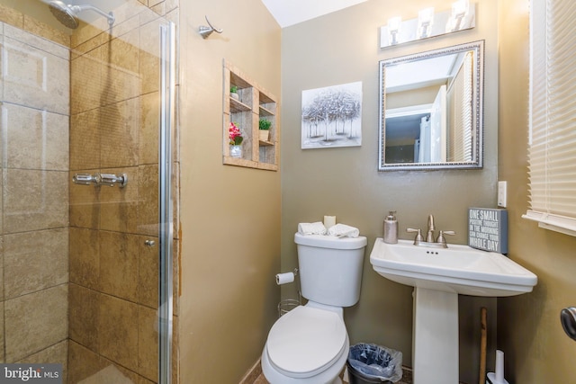 bathroom featuring sink, an enclosed shower, and toilet