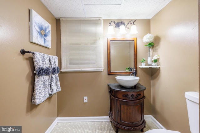 bathroom featuring vanity, a paneled ceiling, tile patterned floors, and toilet