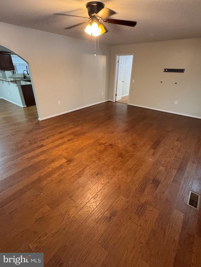 spare room featuring ceiling fan and dark wood-type flooring