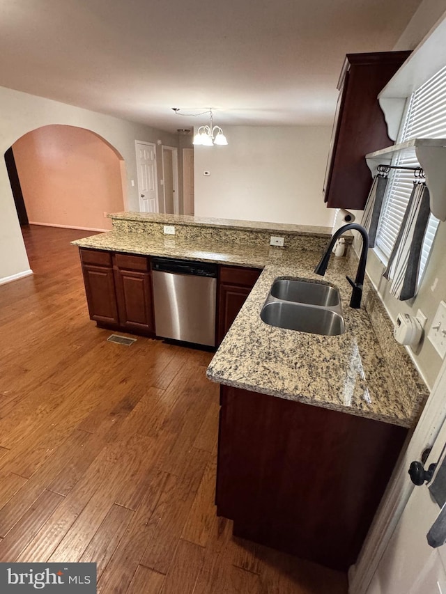 kitchen with an inviting chandelier, sink, stainless steel dishwasher, dark hardwood / wood-style flooring, and kitchen peninsula