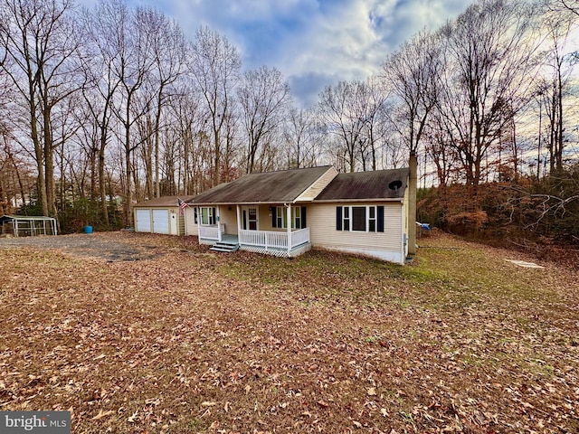 view of front of house with an outdoor structure, a porch, and a garage