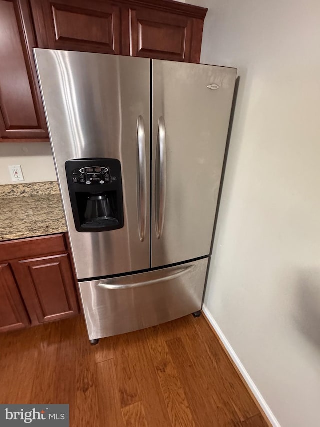 kitchen with stainless steel refrigerator with ice dispenser and light wood-type flooring