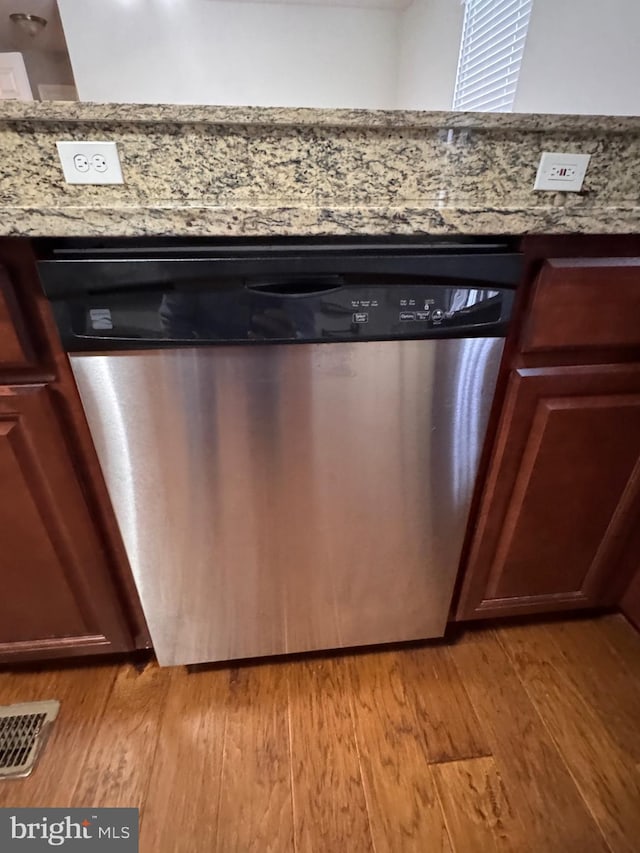 interior details featuring stone counters, dishwasher, and light hardwood / wood-style floors