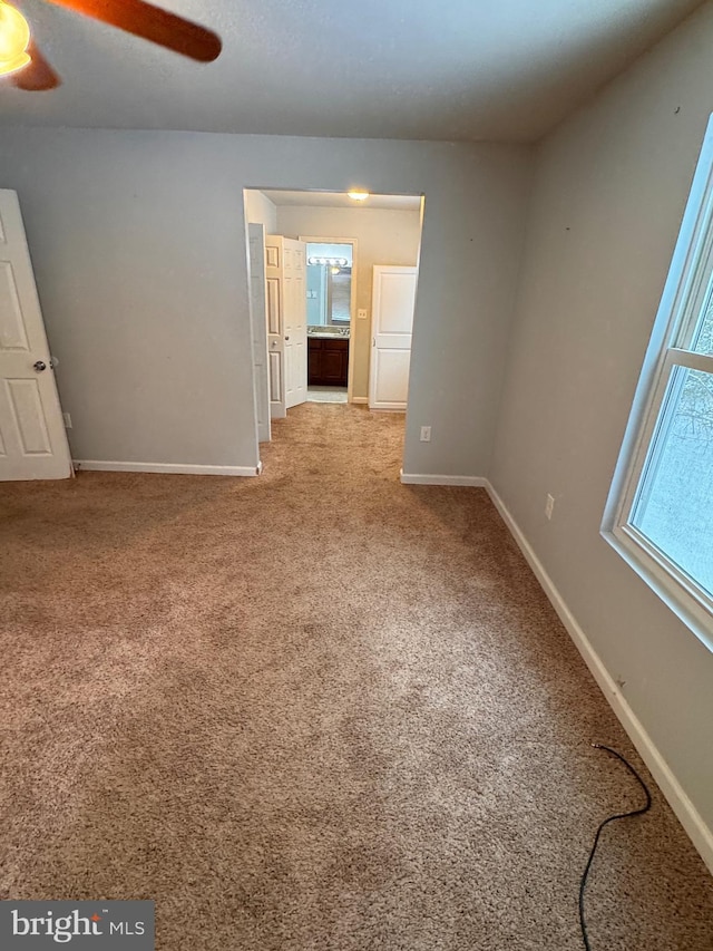 carpeted empty room with ceiling fan and a healthy amount of sunlight