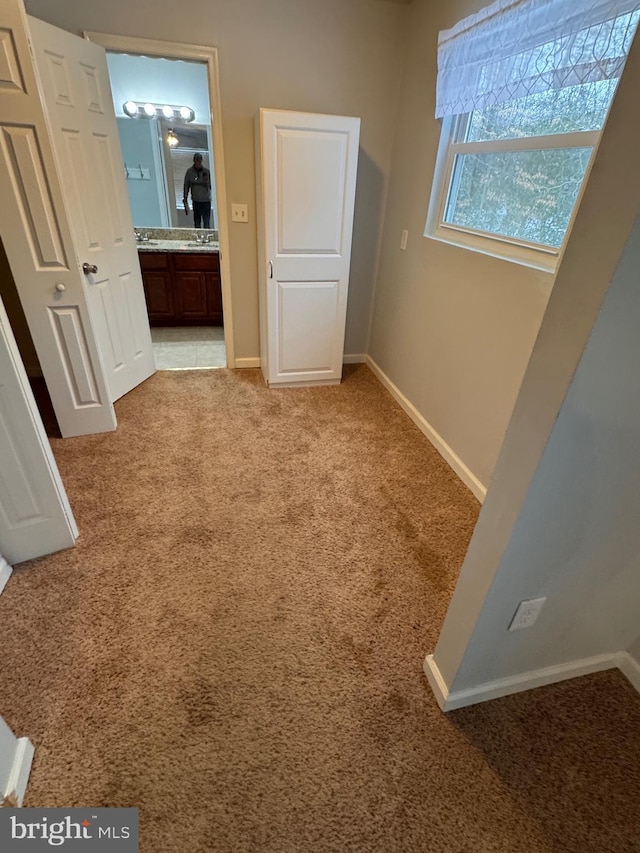 hall featuring light colored carpet