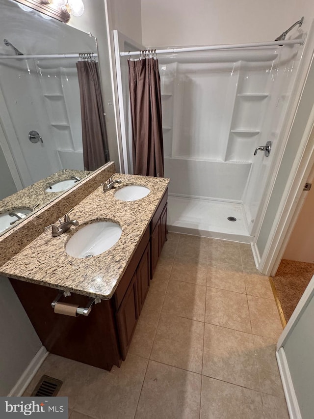 bathroom with tile patterned flooring, vanity, and curtained shower