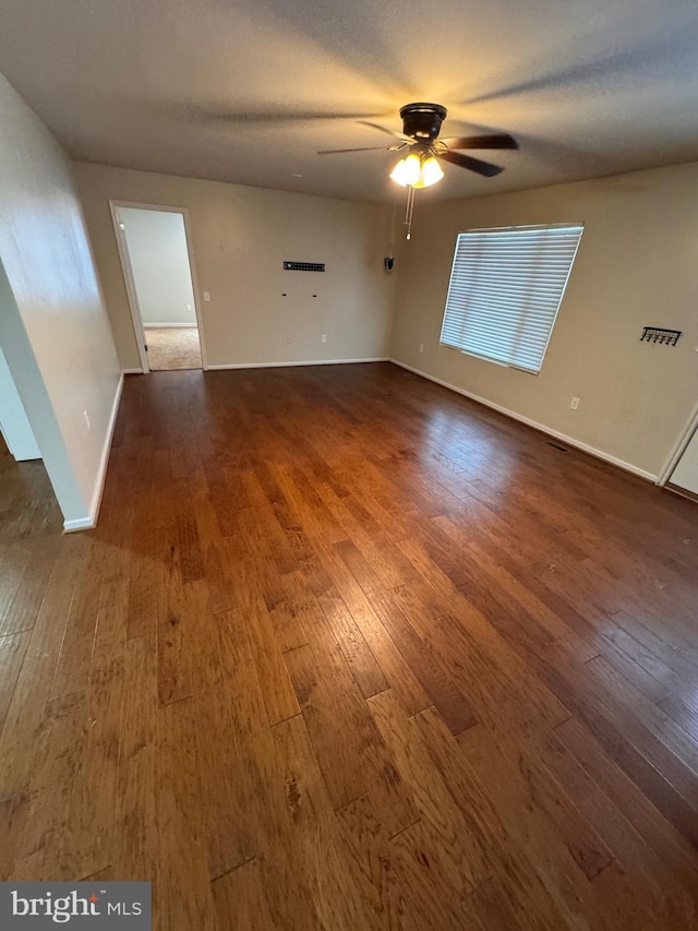 empty room featuring ceiling fan, dark hardwood / wood-style floors, and a textured ceiling