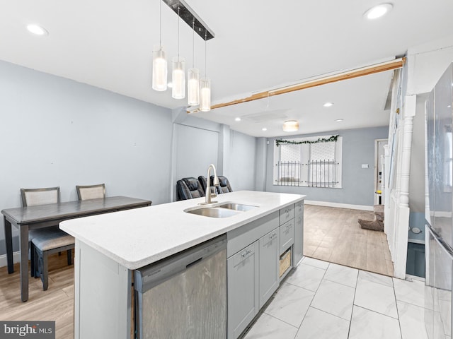 kitchen with sink, gray cabinetry, decorative light fixtures, a center island with sink, and stainless steel dishwasher