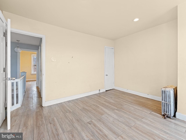 empty room with radiator and light wood-type flooring