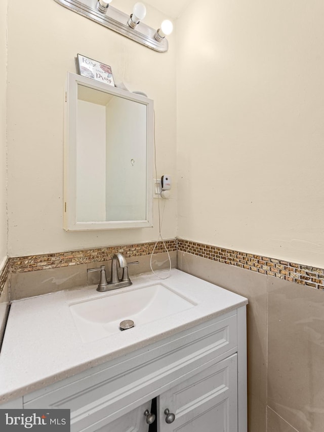 bathroom featuring vanity and tile walls