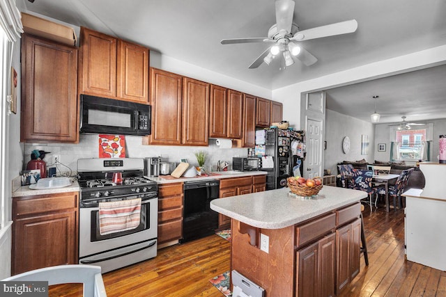 kitchen with open floor plan, light countertops, brown cabinets, dark wood-style floors, and black appliances