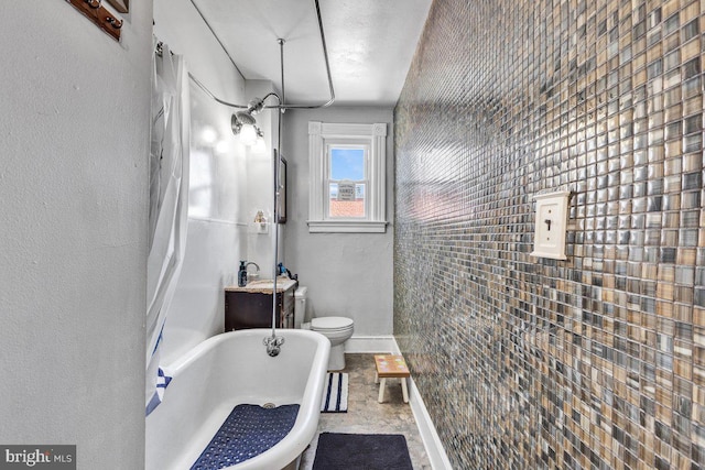 full bathroom with a washtub, baseboards, and toilet