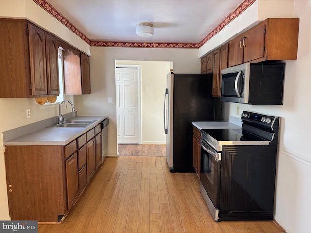 kitchen featuring appliances with stainless steel finishes, light wood-type flooring, and sink