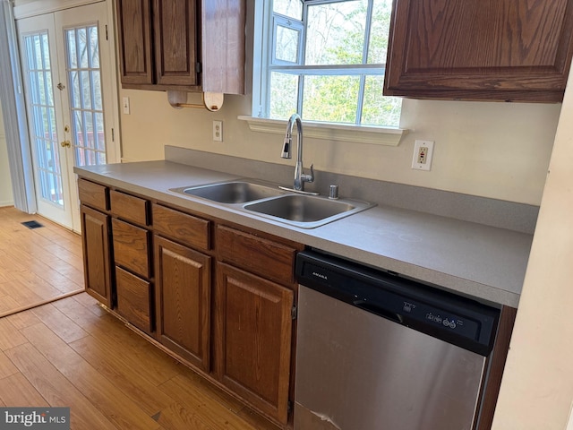 kitchen featuring dishwasher, french doors, light hardwood / wood-style flooring, and sink