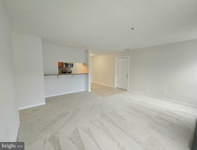 unfurnished living room with light colored carpet