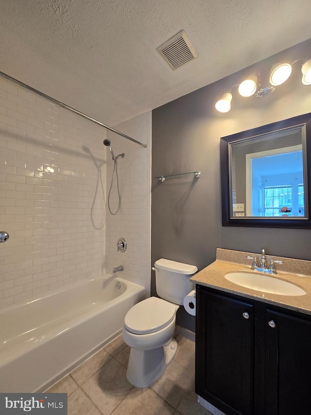 full bathroom with a textured ceiling, tile patterned flooring, toilet, vanity, and tiled shower / bath combo