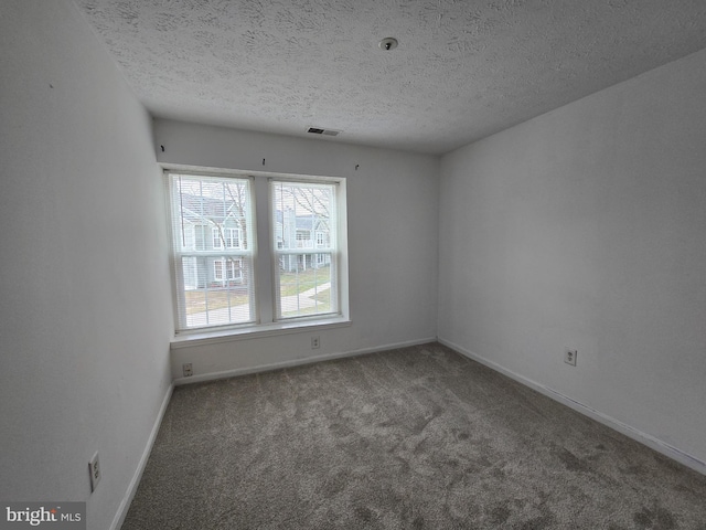 carpeted empty room with a textured ceiling