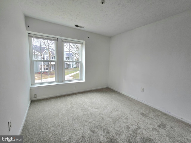 carpeted spare room featuring a textured ceiling