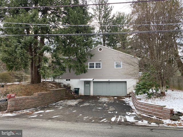 snow covered property with a garage