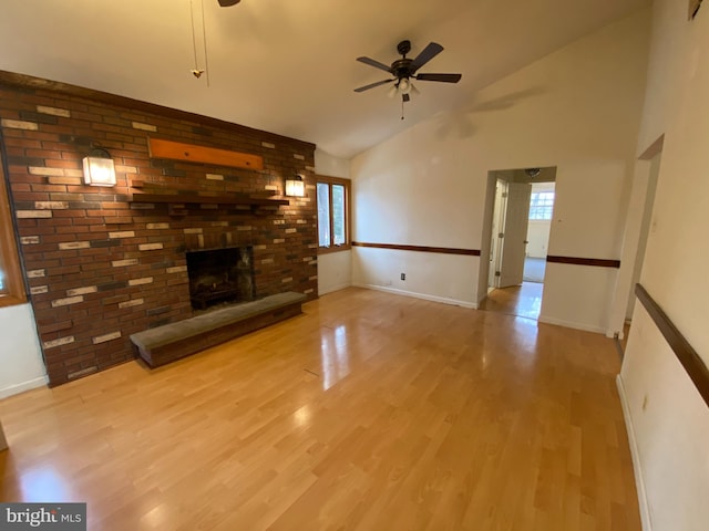 unfurnished living room featuring ceiling fan, light wood-type flooring, high vaulted ceiling, and a fireplace