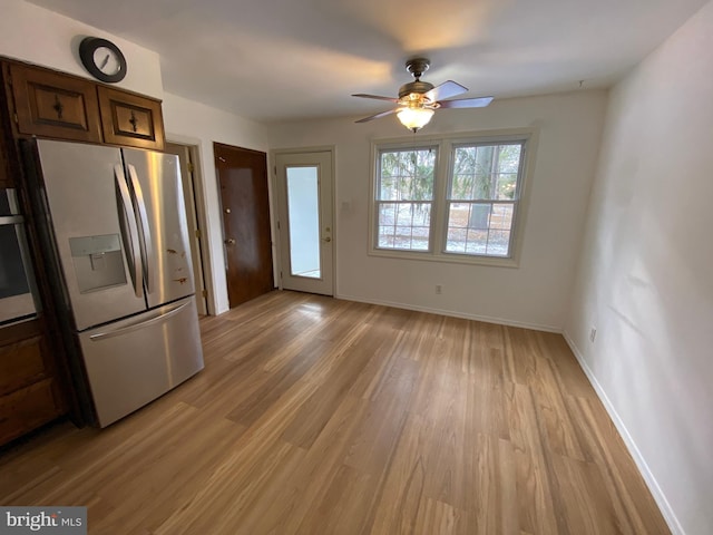 kitchen featuring oven, ceiling fan, light hardwood / wood-style floors, and stainless steel fridge