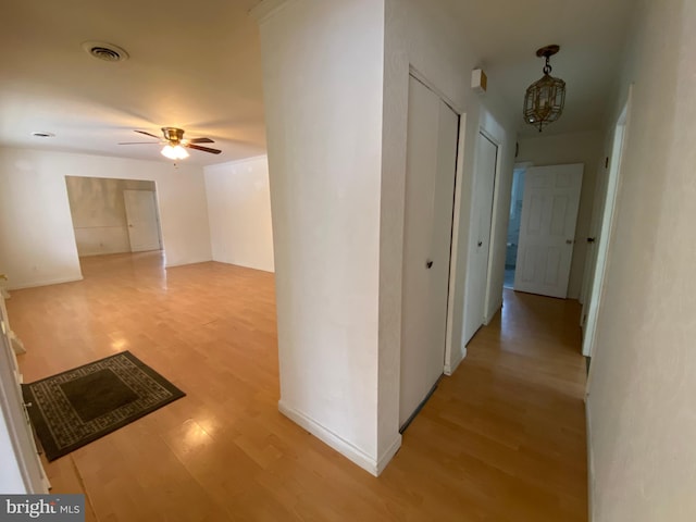 hall featuring a chandelier and light hardwood / wood-style floors