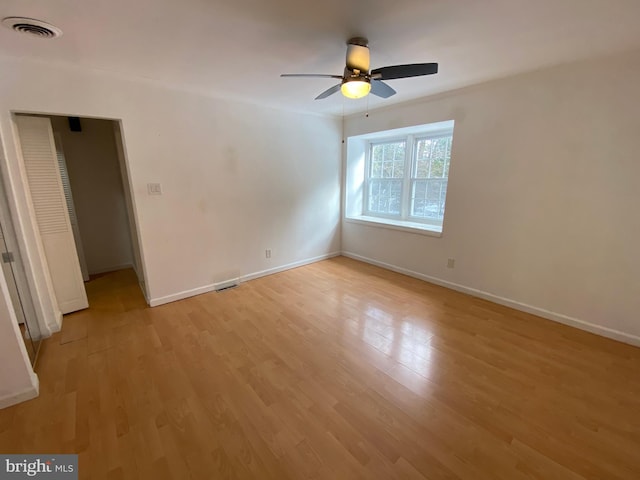 empty room with ceiling fan and light hardwood / wood-style floors