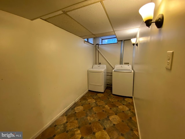 basement with a drop ceiling and washer and clothes dryer