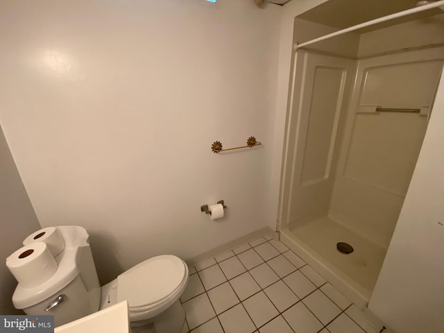 bathroom with toilet, a shower, and tile patterned flooring