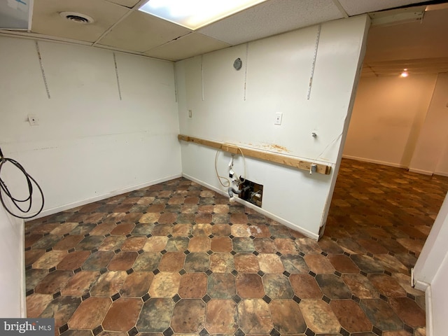 basement featuring a paneled ceiling