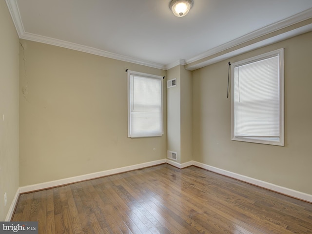 spare room with wood-type flooring and ornamental molding