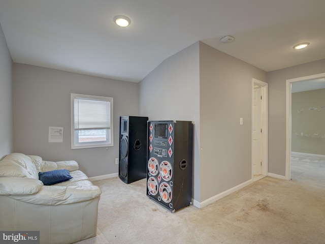 sitting room with light carpet and vaulted ceiling