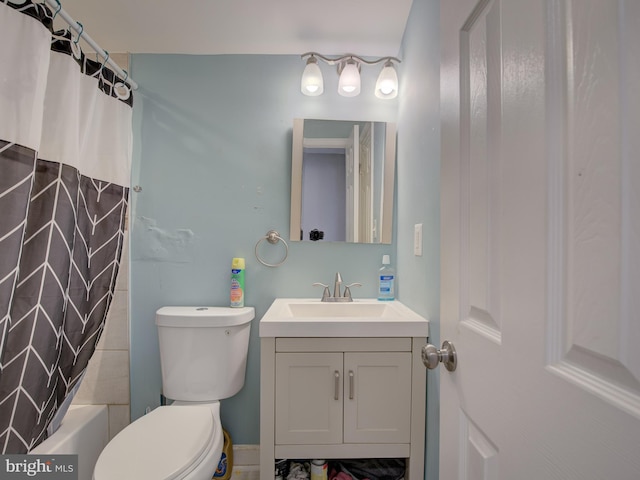 full bathroom featuring shower / bath combo with shower curtain, toilet, and vanity