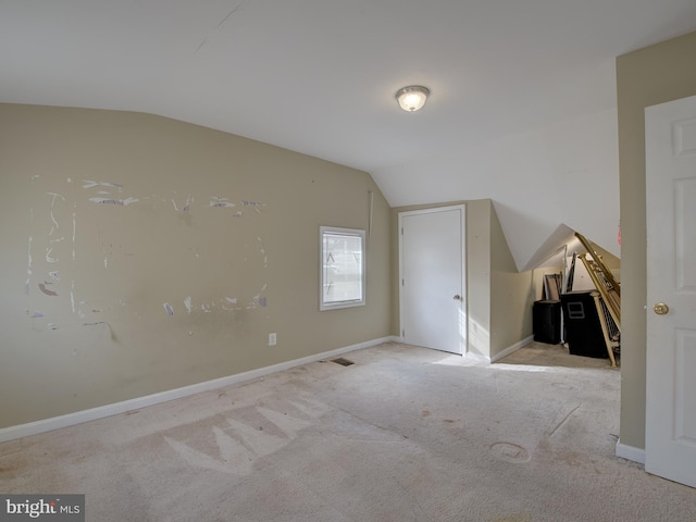 additional living space featuring light carpet and lofted ceiling