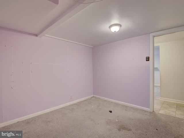 unfurnished room featuring light colored carpet and beamed ceiling