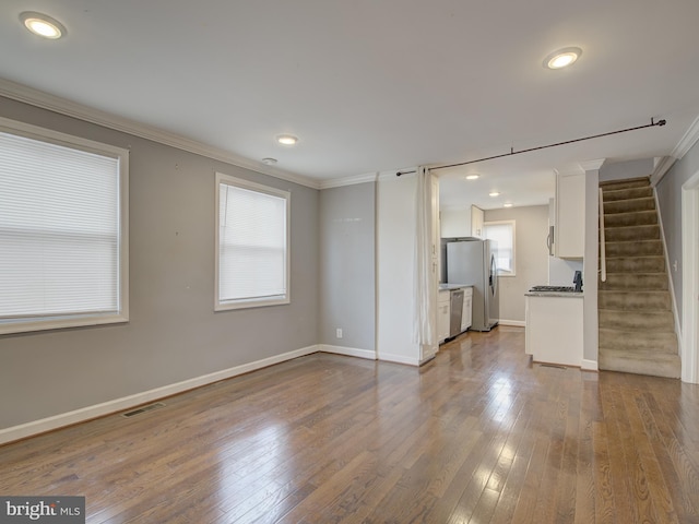 unfurnished living room with crown molding and hardwood / wood-style flooring