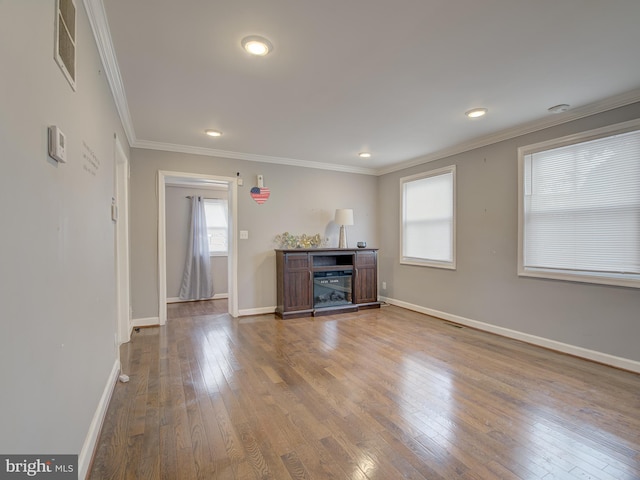 unfurnished living room with wood-type flooring and ornamental molding